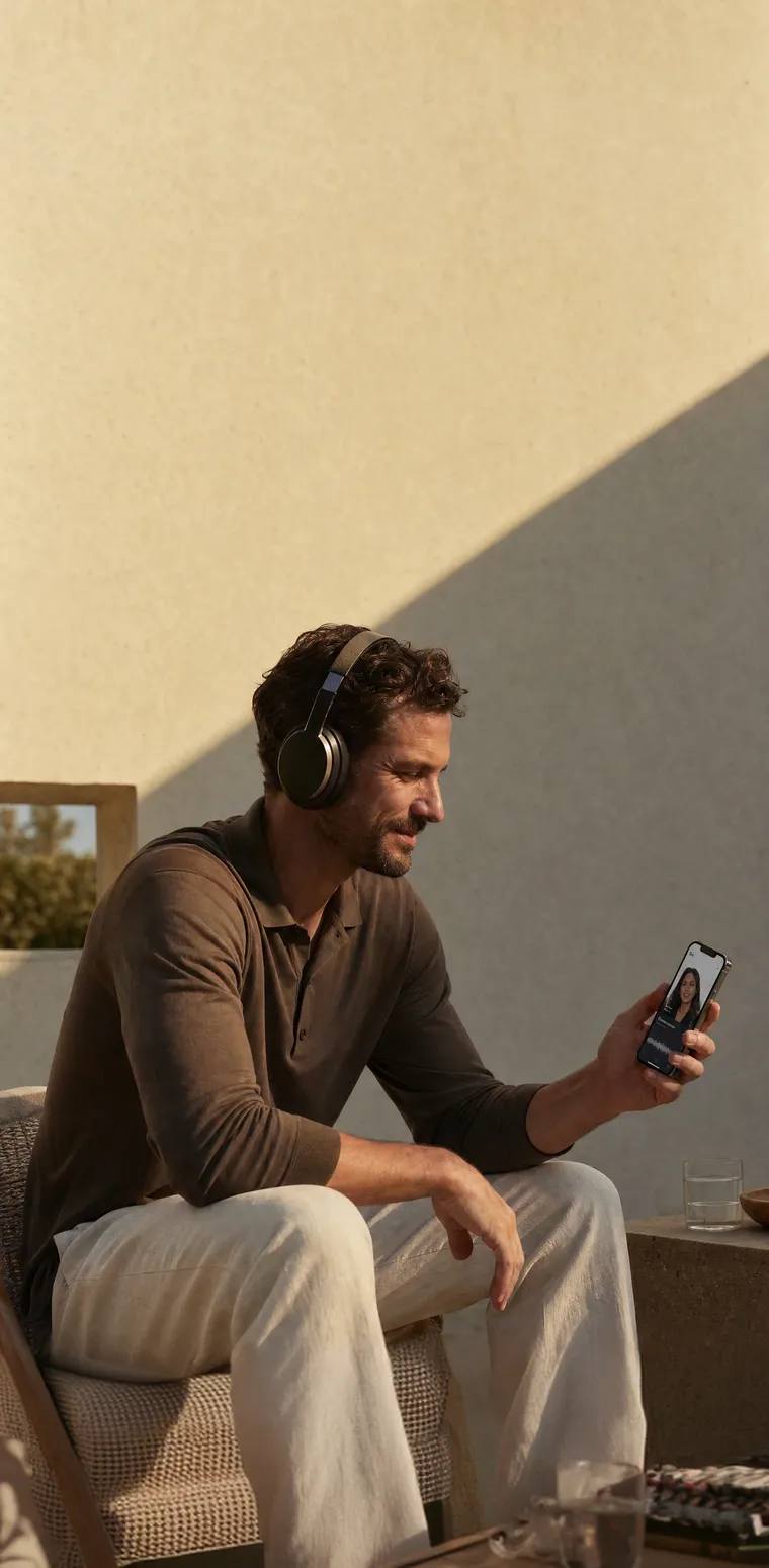 A person sitting relaxed, holding a phone.